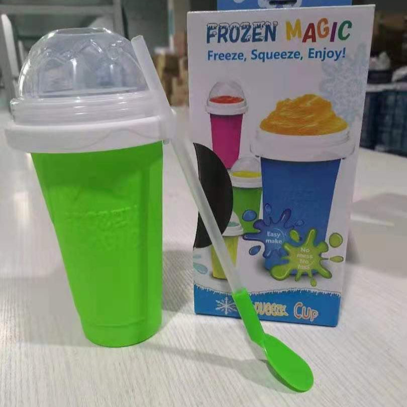 Green slushy maker cup with a spoon and packaging labeled 'Frozen Magic' on a light surface.
