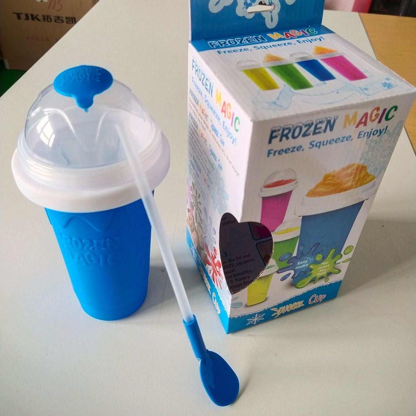 Blue Slushy Maker Cup with a spoon and its packaging on a table
