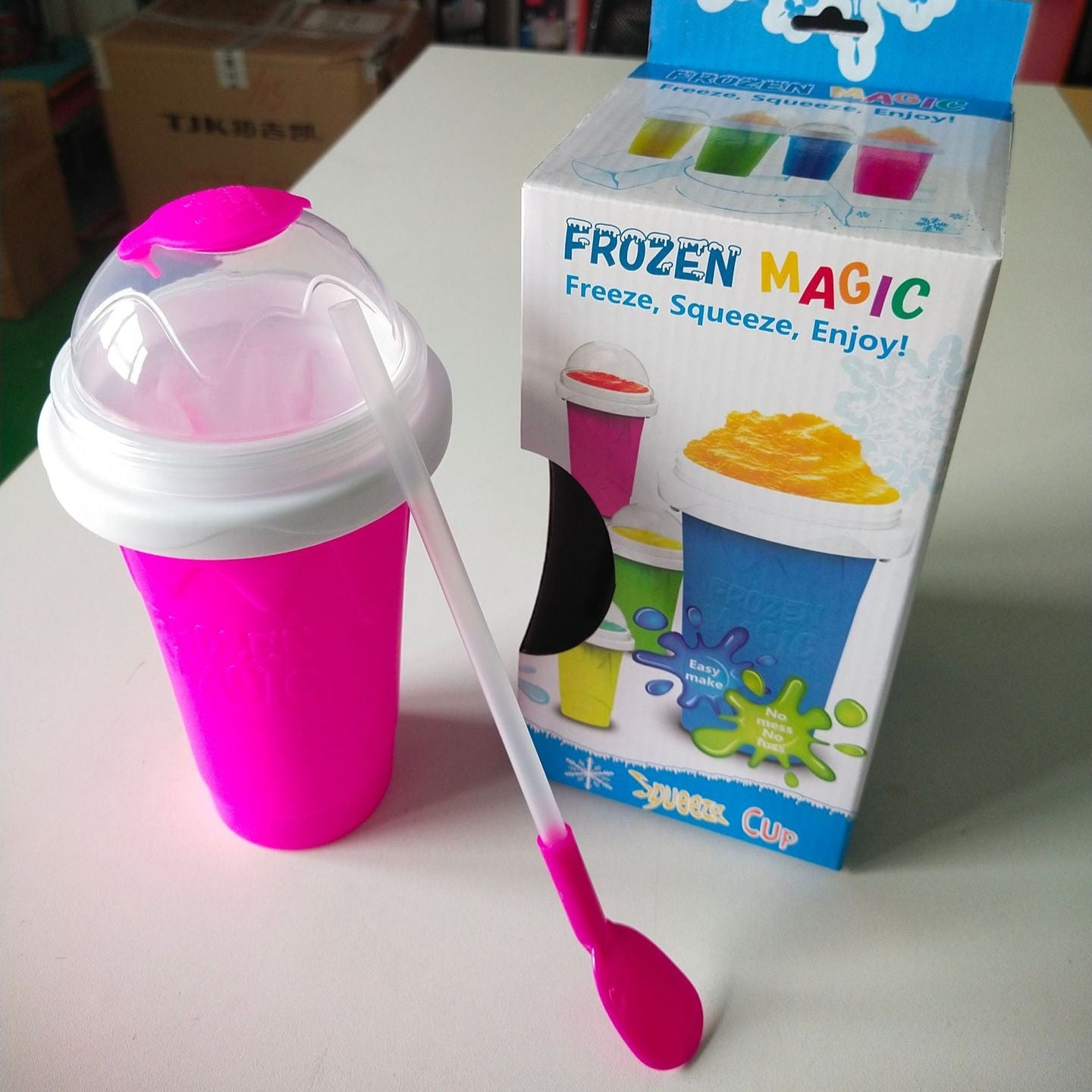 Pink Slushy Maker Cup with spoon and 'Frozen Magic' packaging on a white surface